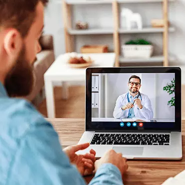 Homem faz consulta online com médico pelo computador