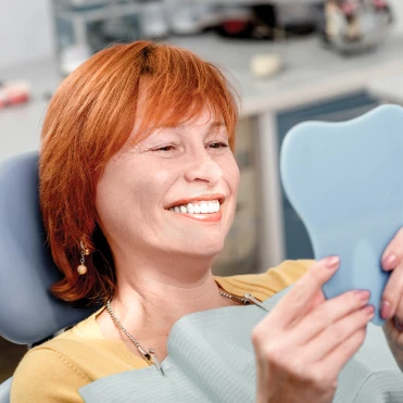 Mulher sorrindo para espelho