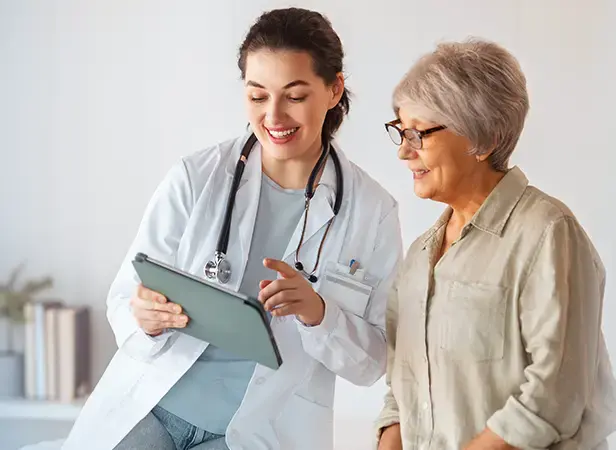 Médica com uma prancheta falando com a paciente.