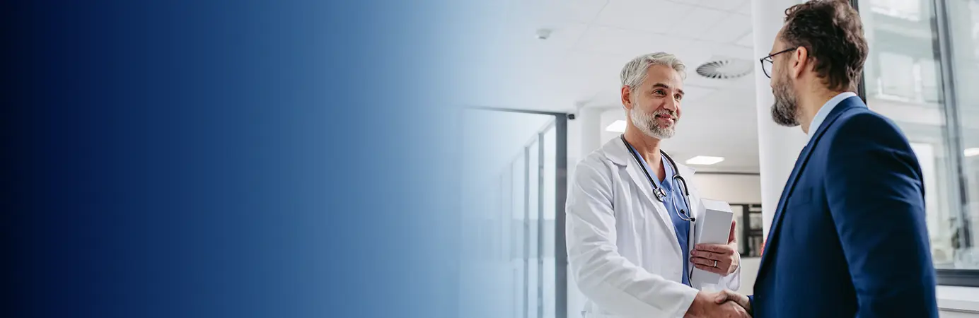 Médico cumprimentado um homem de terno