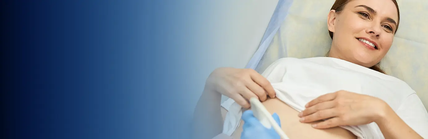 Mulher sorridente deitada em maca de hospital com as mãos na barriga